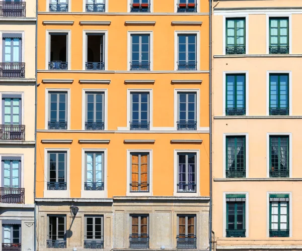 Fachada de un edificio completamente renovada con pintura de colores vivos y aspecto moderno.